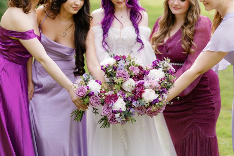 The bride, Kaitlyn from America, and her bridesmaids show off their purple bouquets in the grounds of Solton Manor in Kent