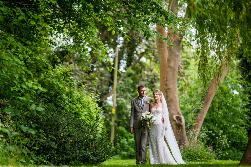 A just married couple walk in the woodlands at Solton Manor, Dover