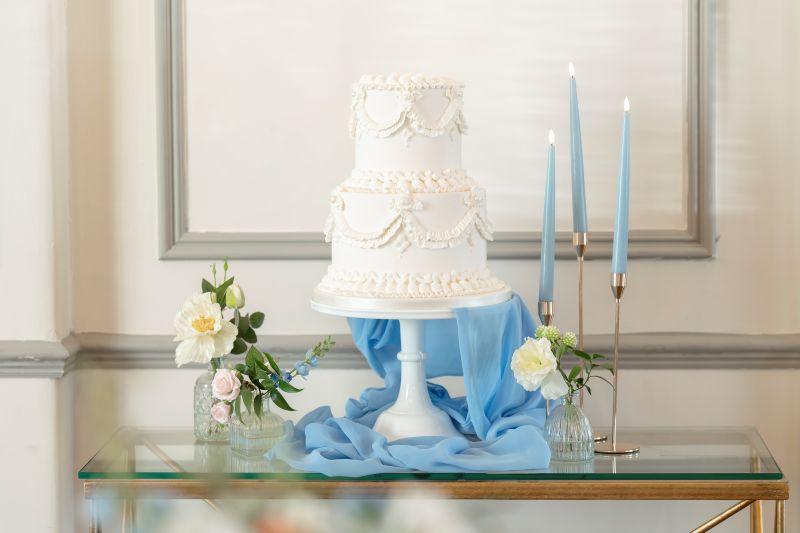 a lambeth cake by shelley's cake displayed in the gallery room for an intimate wedding within solton manor, dover, kent, england