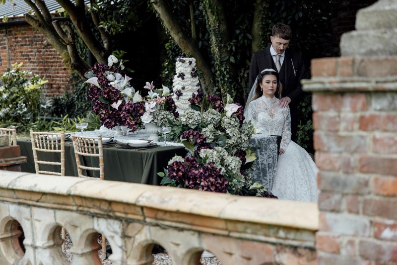 A couple sits next to a styled table, set up outside Solton Manor Country House on the Ponte Vecchio Bridge, Kent, England